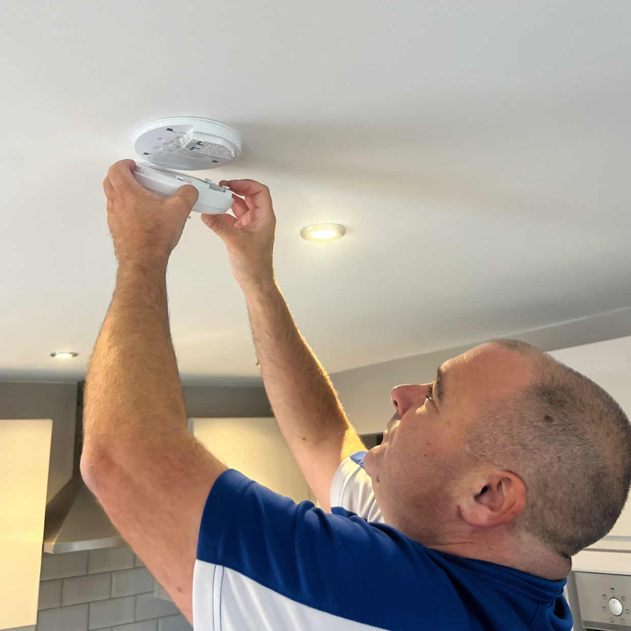 Smoke alarm being installed on a ceiling in Beeston